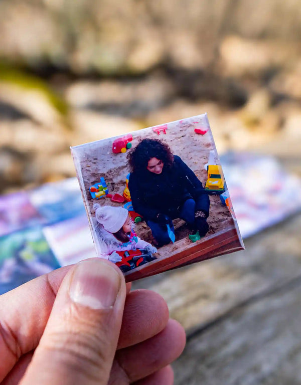 Fotomagnet zeigt Mama und Kind beim Spielen im Sandkasten – eingefangene Augenblicke voller Liebe und Abenteuer.