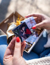Eine Frau hält einen Fotomagneten mit einem Paar, das sich innig im Auto anschaut, voller Liebe.